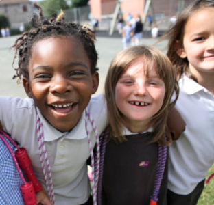 Två unga flickor i uniform imiterar tandborstning med borstar av kartong